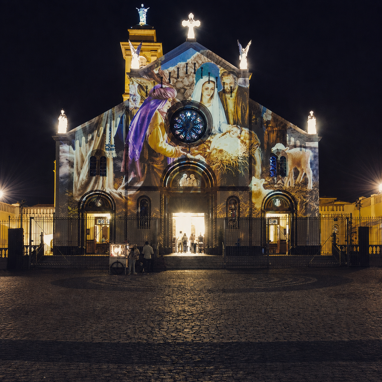 Fachada de igreja recebendo projeção com composição narrativa de tema natalino